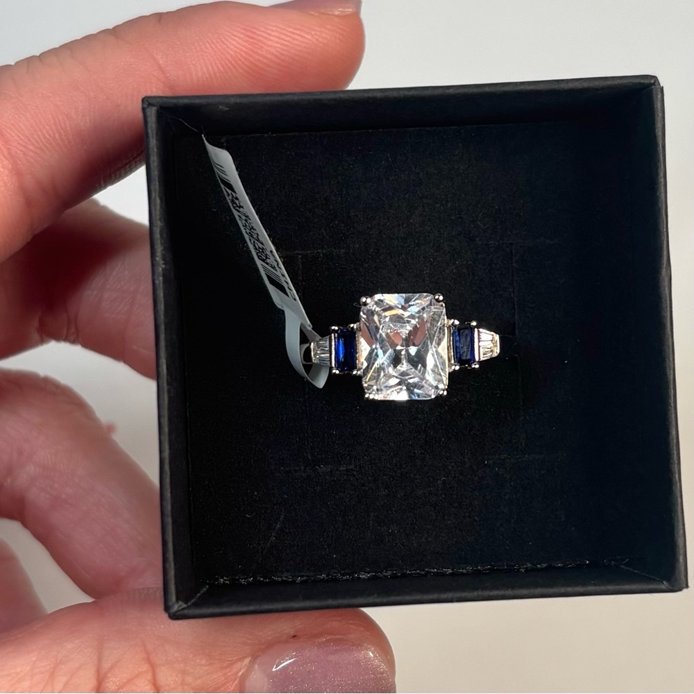 Sterling silver ring with white CZ center stone flanked by deep blue sapphires